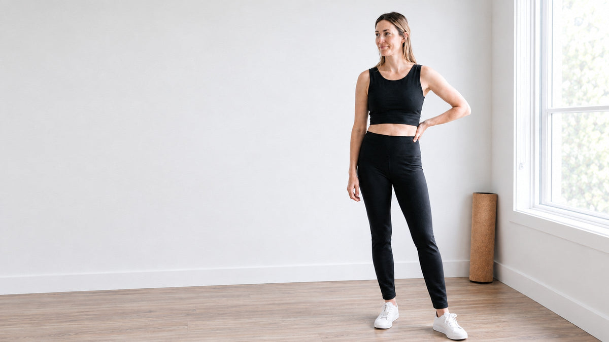 Woman in black organic cotton leggings 30" and Bra / Tank Top in a bright studio