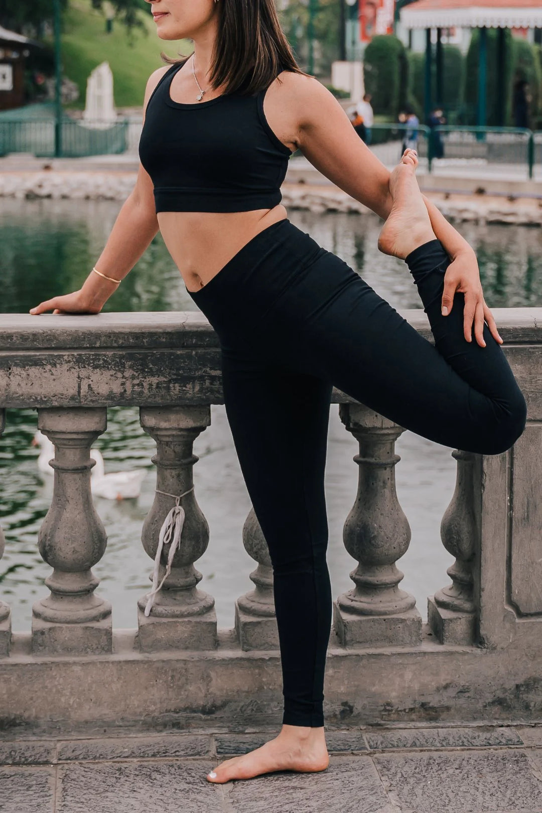 Woman stretching outdoors in black organic cotton leggings 28"