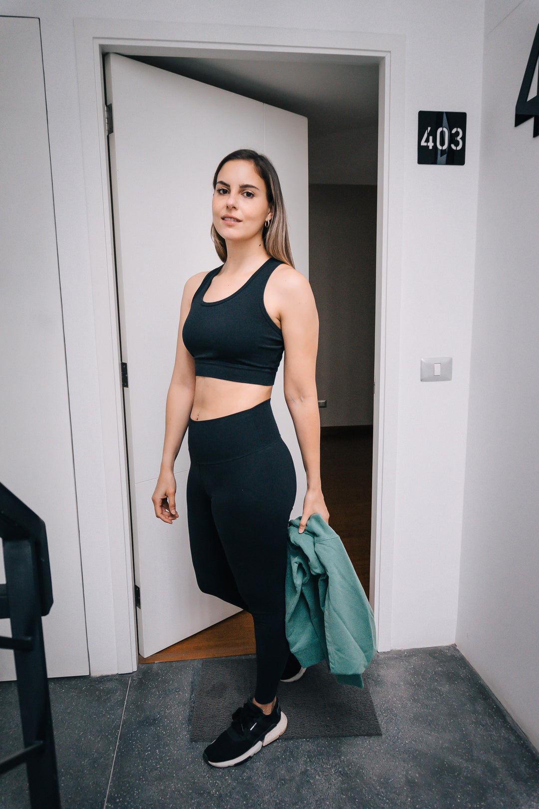 Woman wearing black organic cotton leggings 31" and black organic cotton bra, full body front