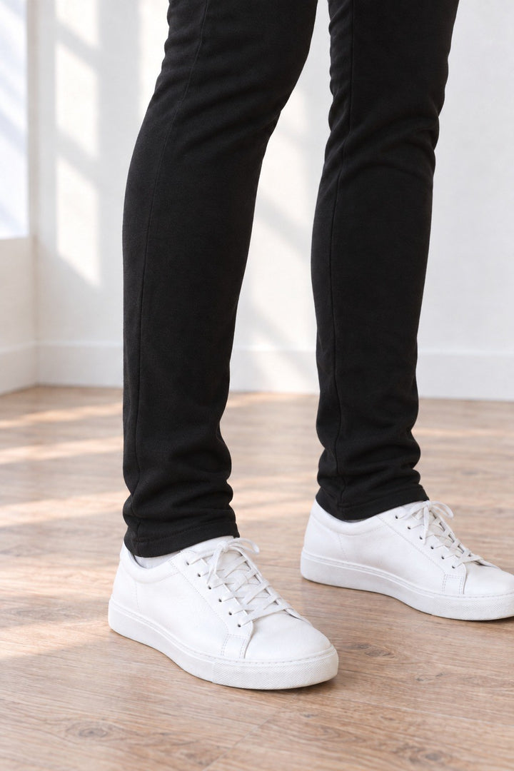 Close-up of the hem of 33" tall organic cotton leggings falling just below the ankle bone over white sneakers